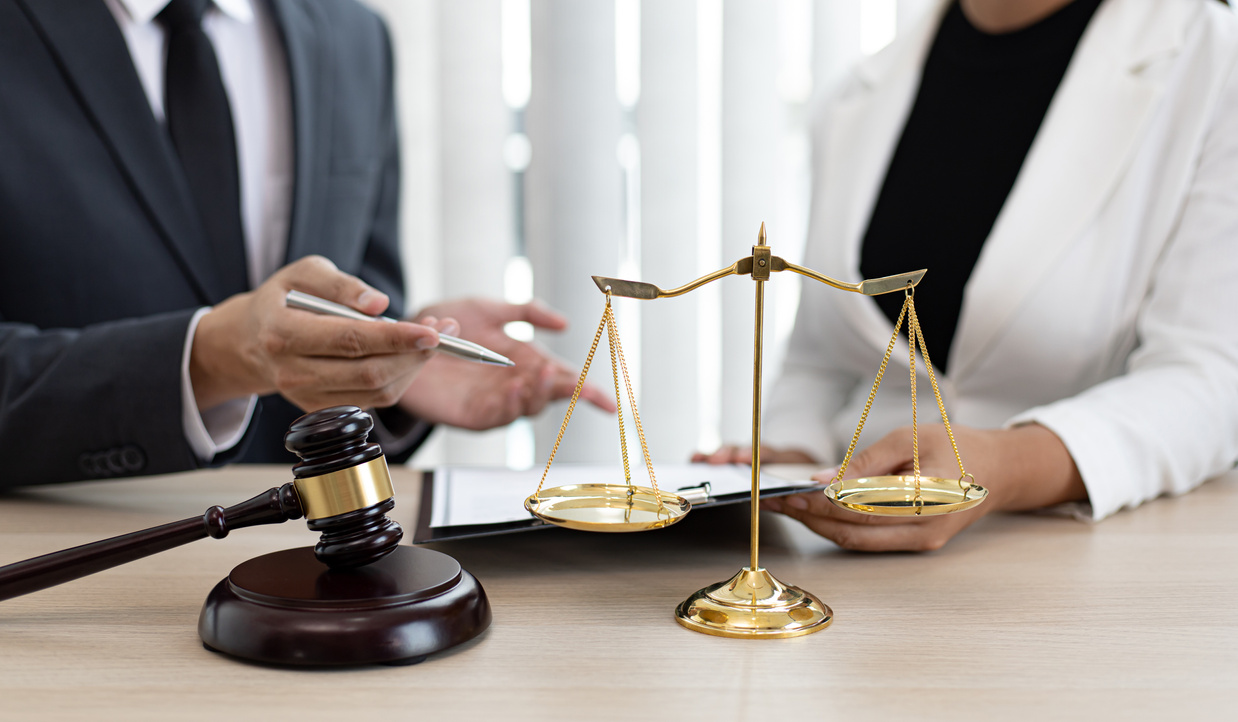 Advogados em análise jurídica com balança da justiça